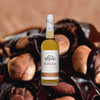 Bottle of Kōloa Kauaʻi Spice Hawaiian Rum over backdrop of dark chocolate and nuts.