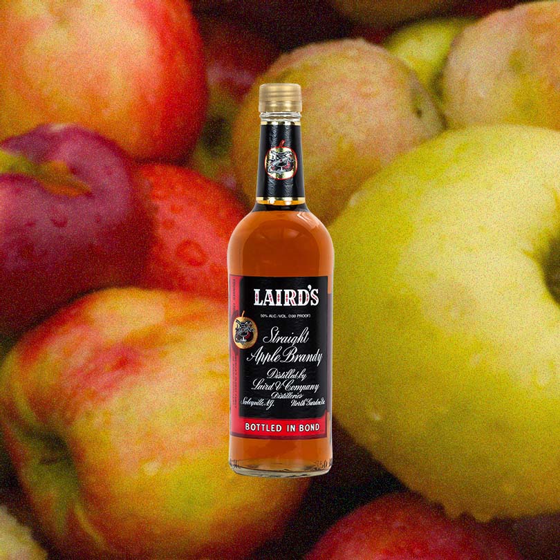 Laird's Straight Apple Brandy 100 Proof Bottled In Bond over backdrop of apples.