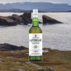 Bottle of Laphroaig 10 Year Single Malt Scotch Whisky over backdrop of Scotland.
