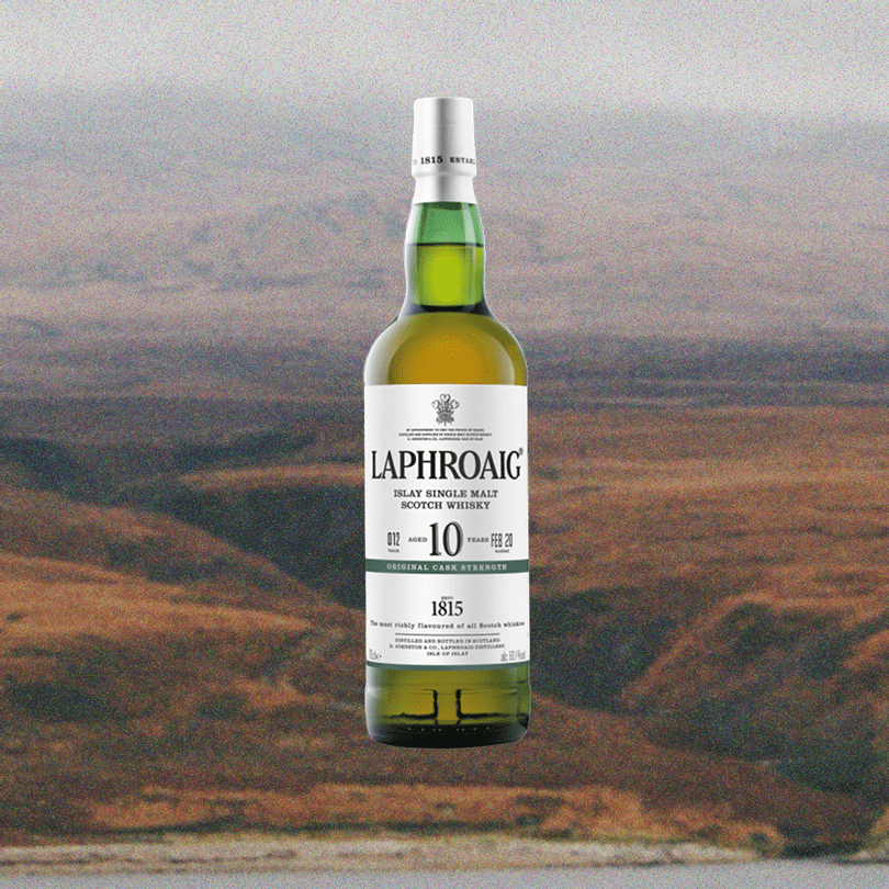 Bottle of Laphroaig 10 Year Cask Strength Single Malt Scotch over a faded picture of a sprawling valley