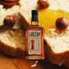 Bottle of Larceny Small Batch Bourbon, over blurred background of bread slices drizzled with honey and spices.