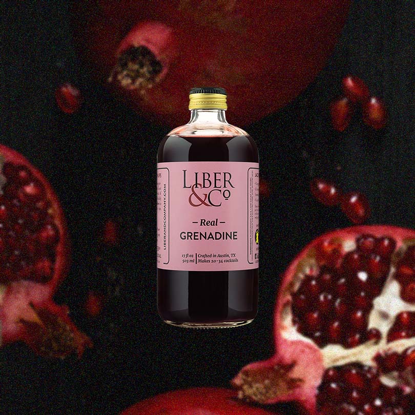 Bottle of Liber & Co. Real Grenadine over background image of pomegranates.