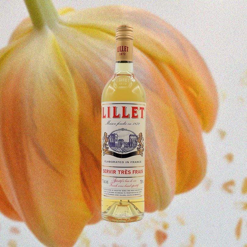 Bottle of Lillet Blanc over light backdrop of a an upside down orange flower.