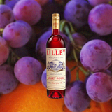 Bottle of Lillet Rouge Aperitif, over blurred background of bright purple grapes.