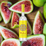 Bottle of Nahmias Mahia Fig Spirit over blurred background of fresh sliced figs.