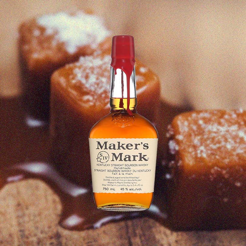750ml bottle of Maker's Mark Bourbon over backdrop of caramel pieces. 