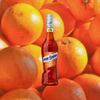 Bottle of Marie Brizard Orange Curaçao over backdrop of bright oranges.