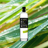Bottle of Mizu Lemongrass Shochu over backdrop of lemongrass with raindrops.