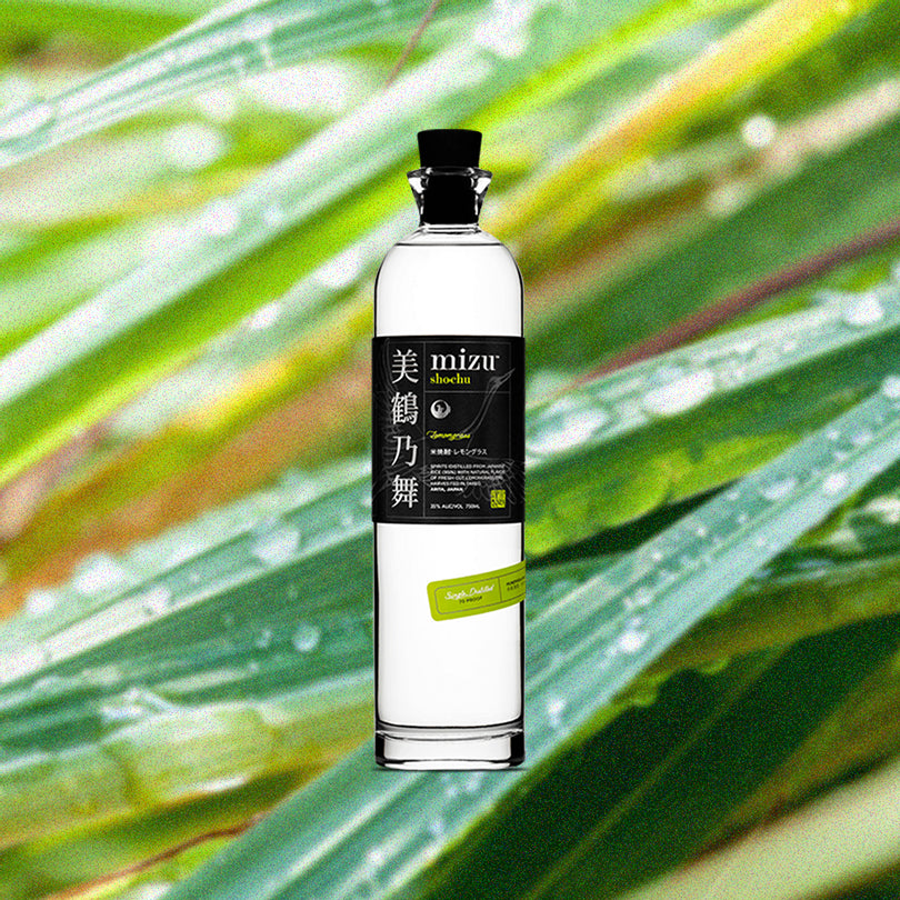 Bottle of Mizu Lemongrass Shochu over backdrop of lemongrass with raindrops.