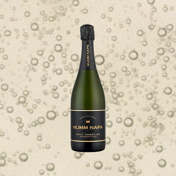 Bottle of Mumm Napa Brut Prestige, over close-up background of sparkling wine.