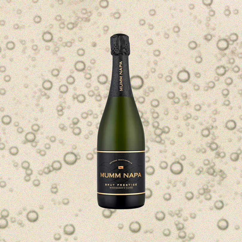 Bottle of Mumm Napa Brut Prestige, over close-up background of sparkling wine.