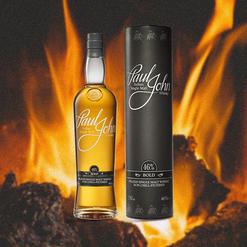 Bottle and package of Paul John Bold Whisky over an image of a fire.