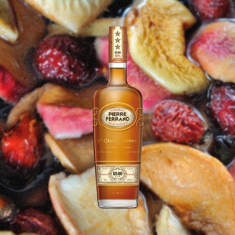 Bottle of Pierre Ferrand Original Formula 1840 Cognac over backdrop of fruits.