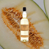 Bottle of Foursquare Probitas White Blended Rum over backdrop of seeded fruit.