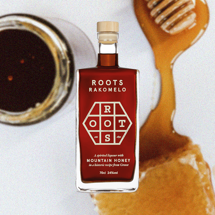 Bottle of Roots Rakomelo Sweet Liqueur, a jar of honey, and honeycomb covered in honey.