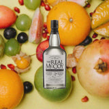 Bottle of The Real McCoy 3 Year Rum over backdrop of assorted fruits and figs.