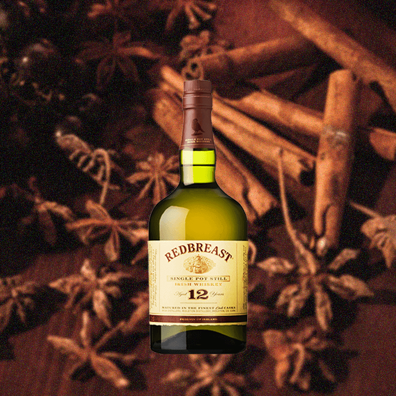 Bottle of Redbreast 12 Year Irish Whiskey over background of cinnamon and other spices. 