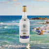 Bottle of Rhum Barbancourt White Rum over backdrop of the ocean.