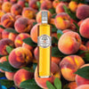 Bottle of Rothman & Winter Orchard Peach Liqueur over blurred background of whole peaches.