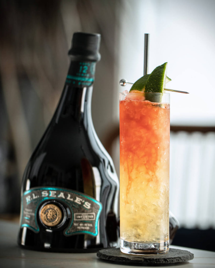 R.L. Seale’s Finest Barbados 12 Year Rum on a table next to a rum and tonic.