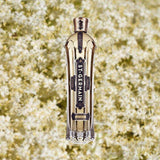 Bottle of St. Germain Elderflower Liqueur over blurry elderflower background.