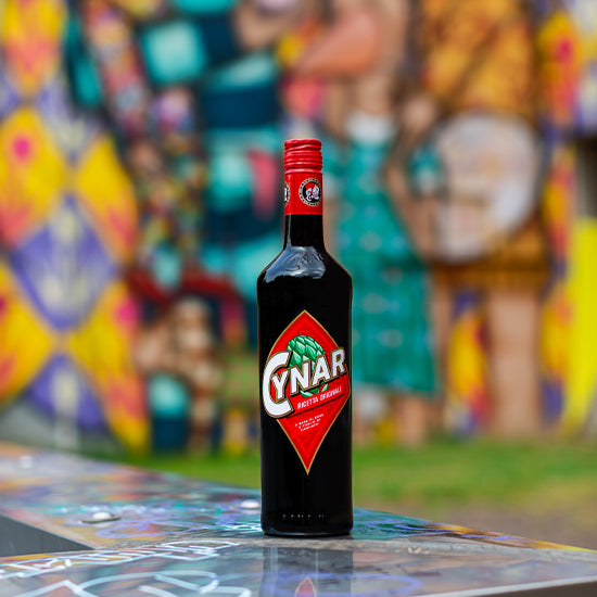 Bottle of Cynar over a blurred graffiti background.