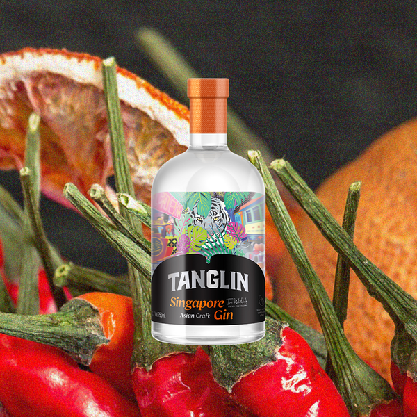 Bottle of Tanglin Singapore Gin over backdrop of chilies and spices.