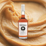 Bottle of Skrewball Peanut Butter Whiskey. Backdrop of Peanut Butter.