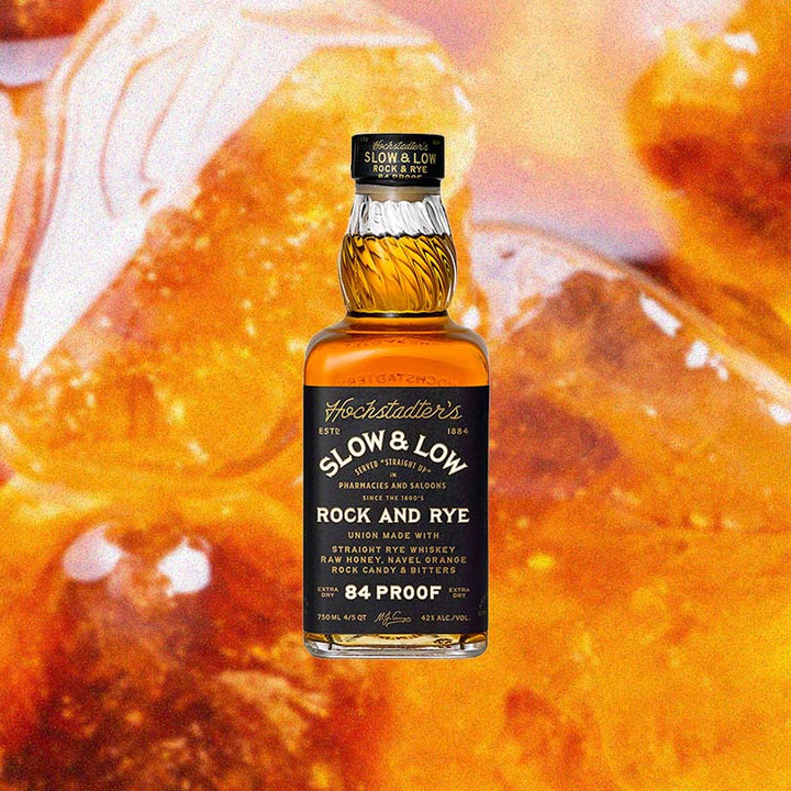 Bottle of Hochstadter's Slow & Low Rock and Rye over backdrop of orange candy.
