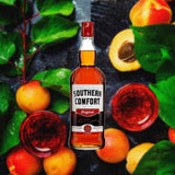 Bottle of Southern Comfort over backdrop of peaches.