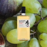 Bottle of Suntory Toki Japanese Whisky over backdrop of grapes.