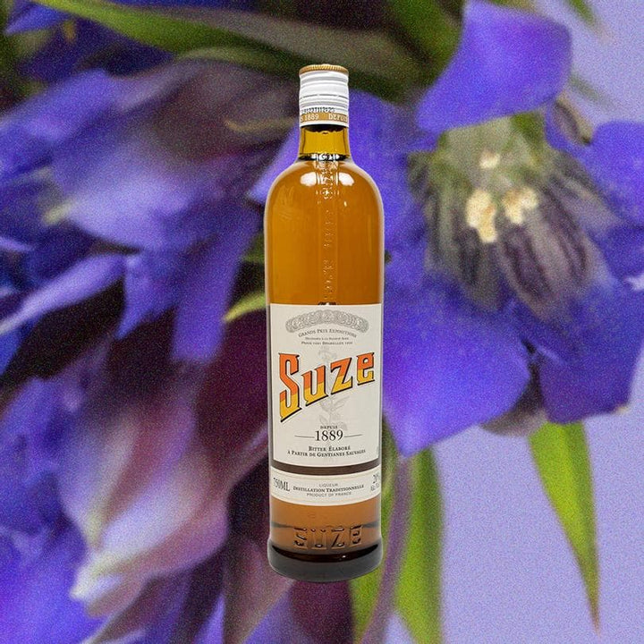 Bottle of Suze Aperitif over background of large purple flower.