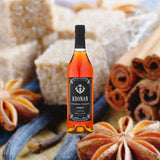 Bottle of Kronan Swedish Punsch over backdrop of baked goods and spices.