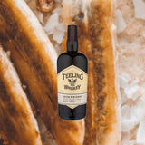 Bottle of Teeling Small Batch Irish Whiskey, over close-up background of sugar and dried fruit.