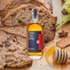 750ml bottle of Ten to One Caribbean Dark Rum over backdrop of bread, toast and honey dipper.