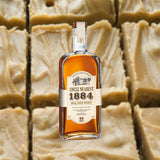Bottle of Uncle Nearest 1884 Small Batch Whiskey in front of backdrop of peanut butter fudge.