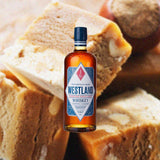 Bottle of Westland Flagship American Single Malt Whiskey over backdrop of baked goods.