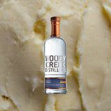 Bottle of Woody Creek Potato Vodka over backdrop of butter or vanilla.