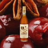 Bottle of Yellowstone Select Kentucky Straight Bourbon over backdrop of red cherries up close.