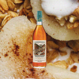 Bottle of Yellowstone American Single Malt Whiskey over backdrop of a close up of pie.