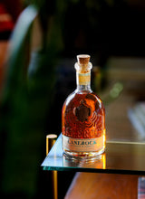 Bottle of Canerock Spiced Rum in dark lighting on the corner of a table.