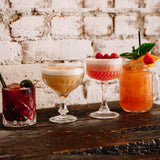 Two cocktails on a wooden bar.